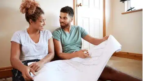 Young couple looking at a floor plan to redecorate.