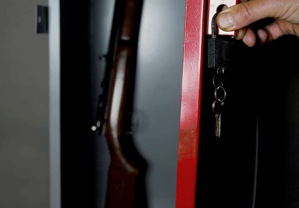 A hunting rifle stored inside a locked gun safe.